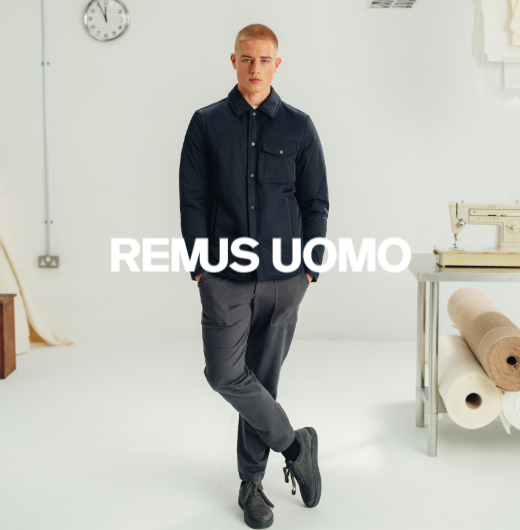 Man wearing navy shacket, grey trousers and black casual shoes